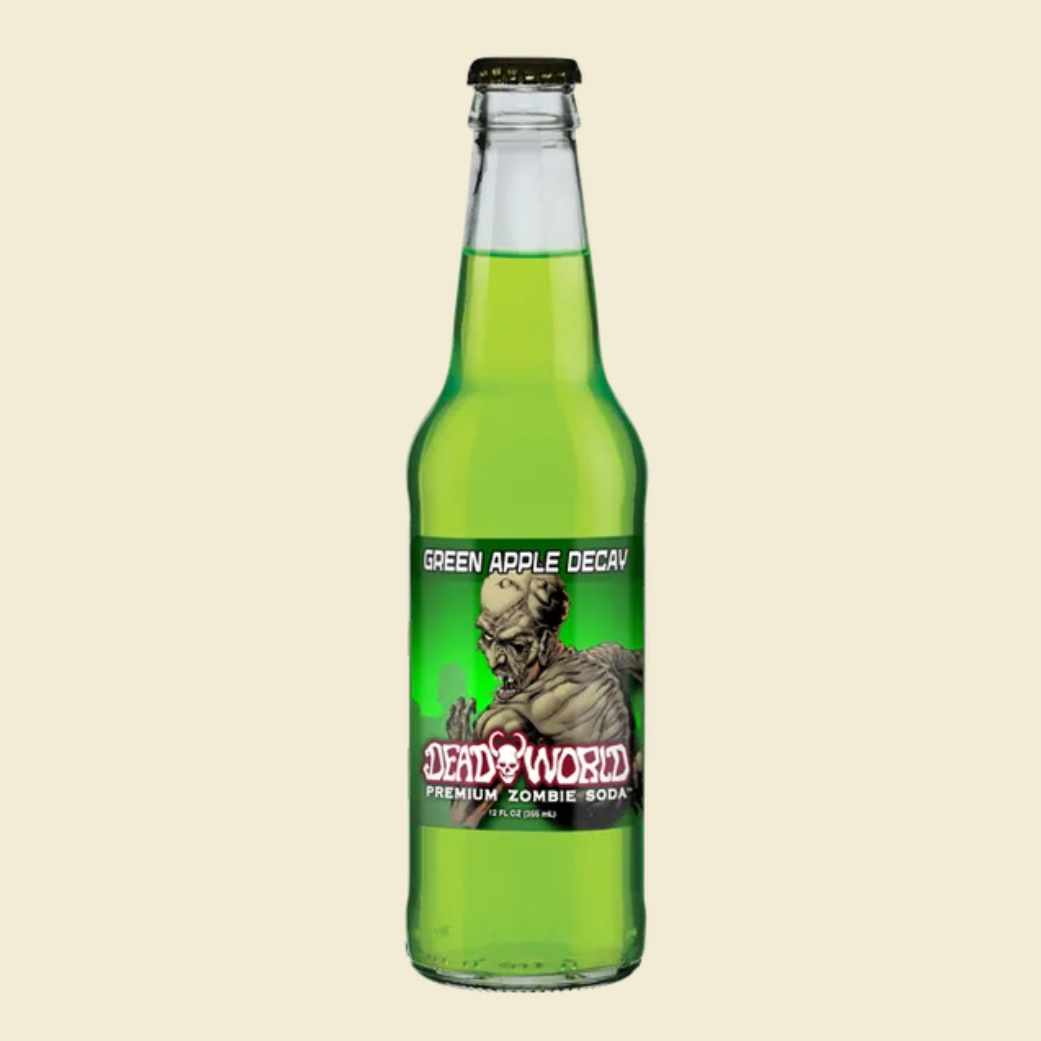 A glass bottle of Deadworld Green Apple Decay premium zombie soda, filled with a bright green liquid, set against a light beige background with text below.