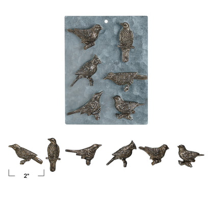 Set of bird-shaped metal decorations on a blue background with a scale indicator.